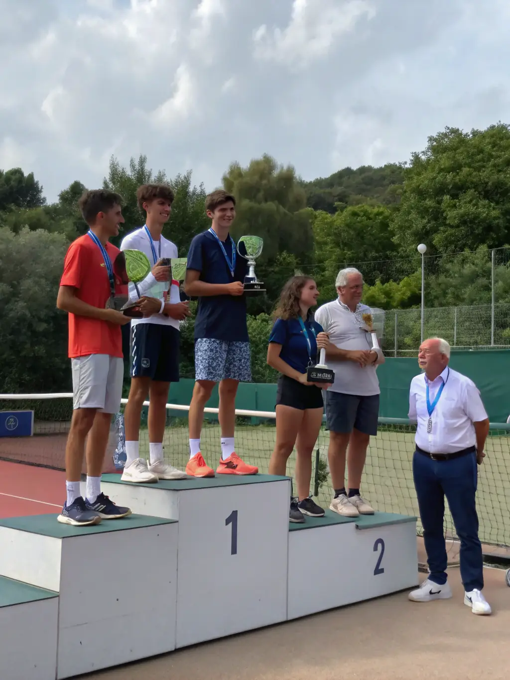 A dynamic shot of the CMTC Summer Tournament trophy presentation, showcasing the winners and participants with the CMTC banner in the background.